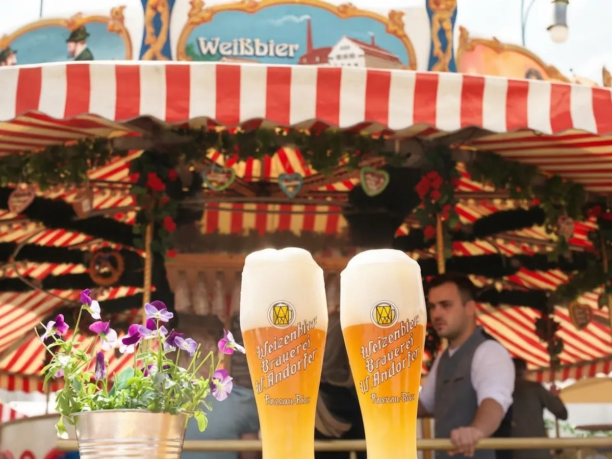 Zwei Weißbier im Vordergrund, das Karussell im Hintergrund
