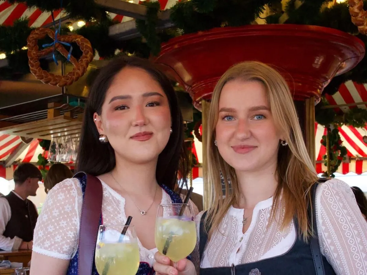 Zwei Frauen im Karussell mit Aperol in der Hand