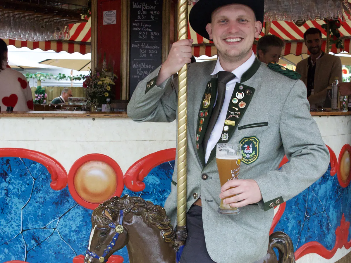 Ein Mann in Tracht auf einem Karussellpferd